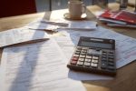 Calculatrices et documents fiscaux en gros plan, illustrant des stratégies de gestion financière complexe.