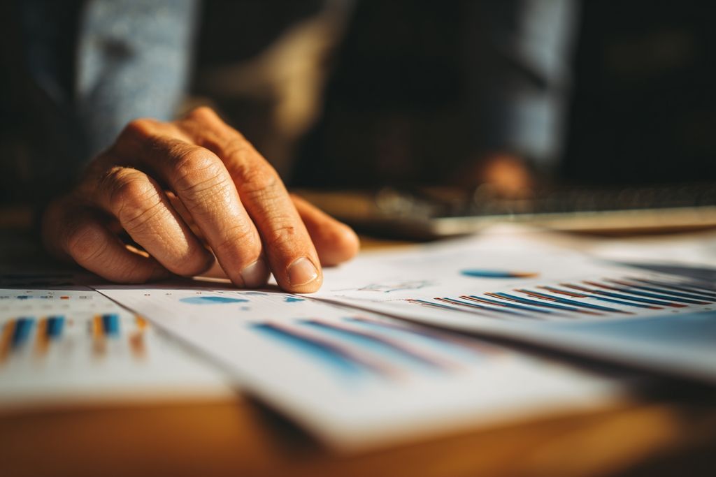 Gros plan des mains sur rapports financiers illustrant une analyse réfléchie