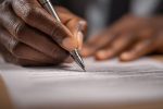 Une personne analyse attentivement un contrat pour garantir la précision du langage juridique