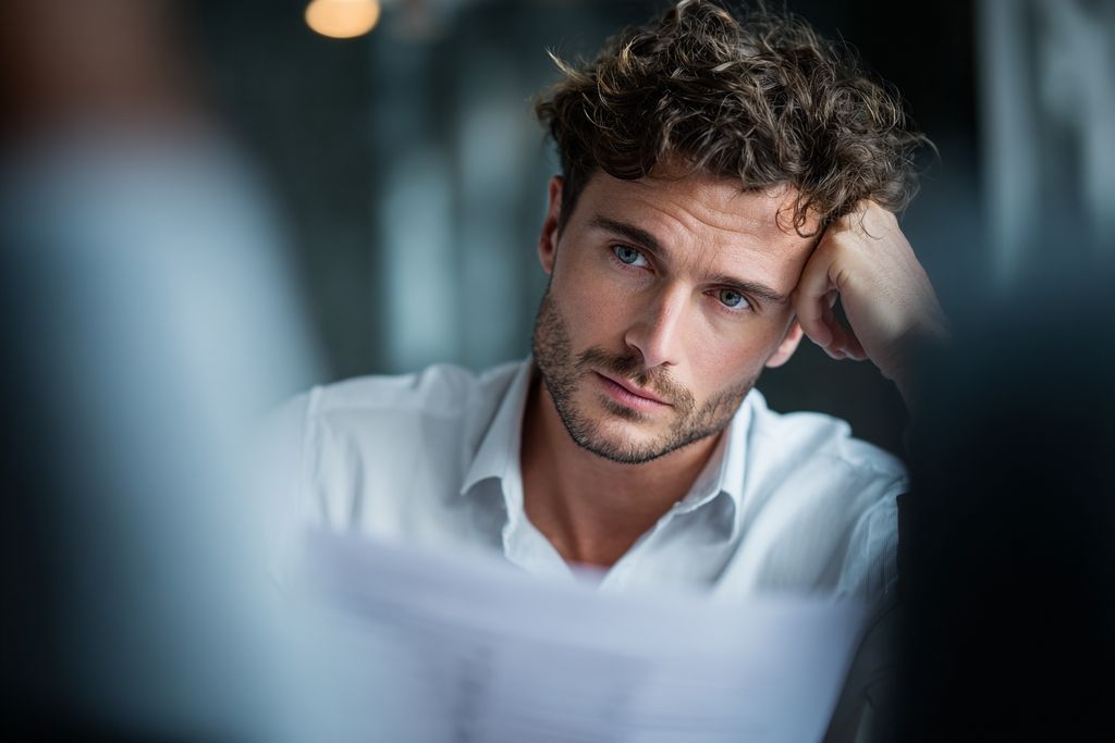 Visage préoccupé d'un dirigeant examinant des rapports financiers