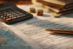 Image de gros plan de formulaires fiscaux et de calculs sur un bureau, importance d'une déclaration précise.